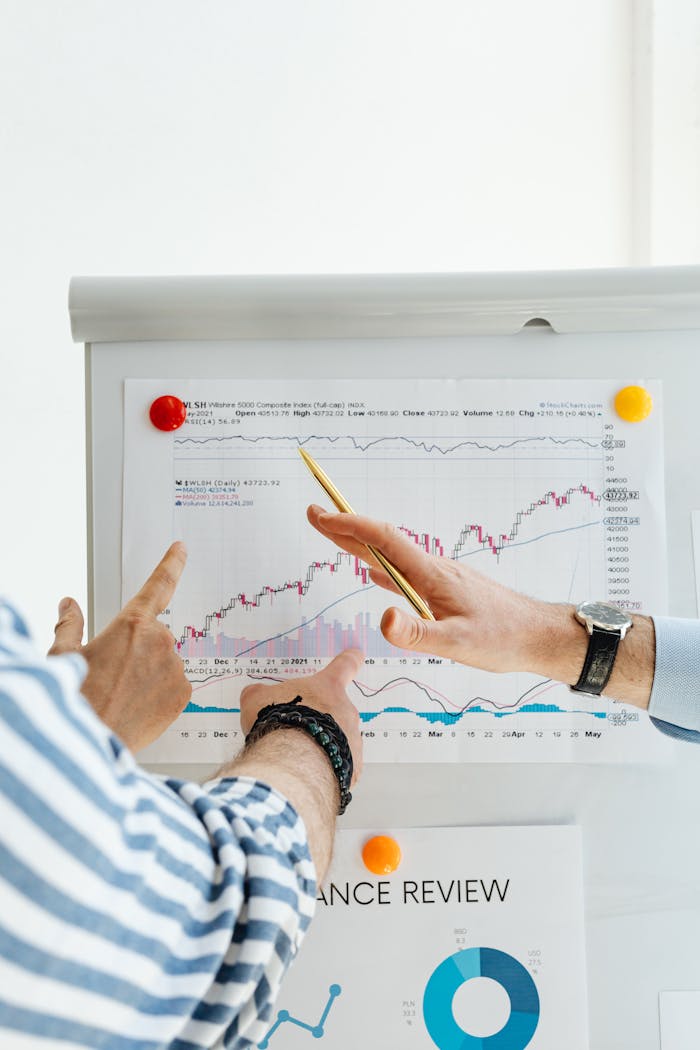 Gallery-4 Two People Analyzing Financial Charts On A Whiteboard During A Business Meeting.